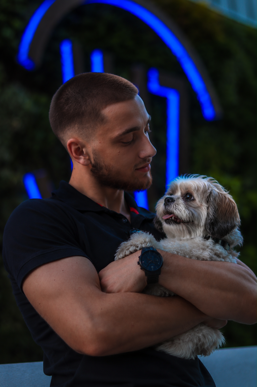 Michał cradling a small shih tzu in his arms